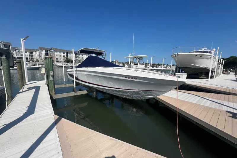 The Image of 1999 Wellcraft Scarab 302 Sport boat on stands outside a warehouse. - 0