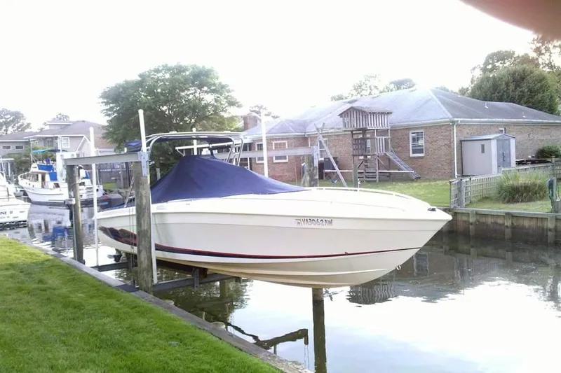 Slide: The Image of 1999 Wellcraft 302 Scarab Sport boat docked at a marina under clear blue skies. - 1