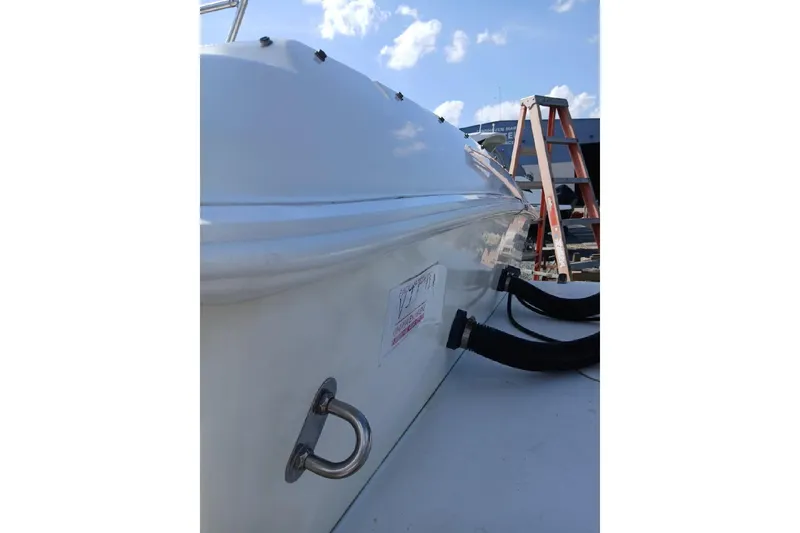 Slide: The Image of 1999 Wellcraft Scarab 302 Sport boat docked under a clear blue sky. - 12