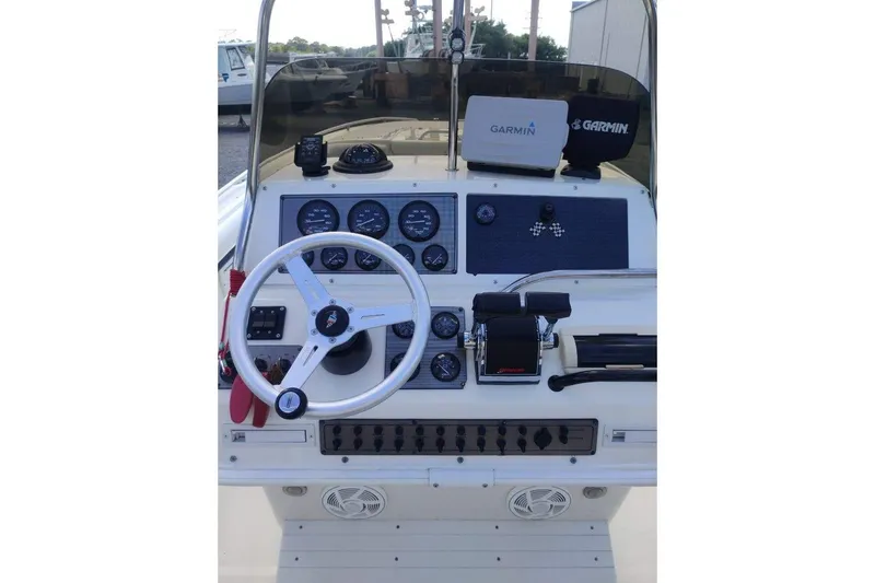 Slide: The Image of 1999 Wellcraft Scarab 302 Sport boat on dry dock, white hull, clear sky background. - 16