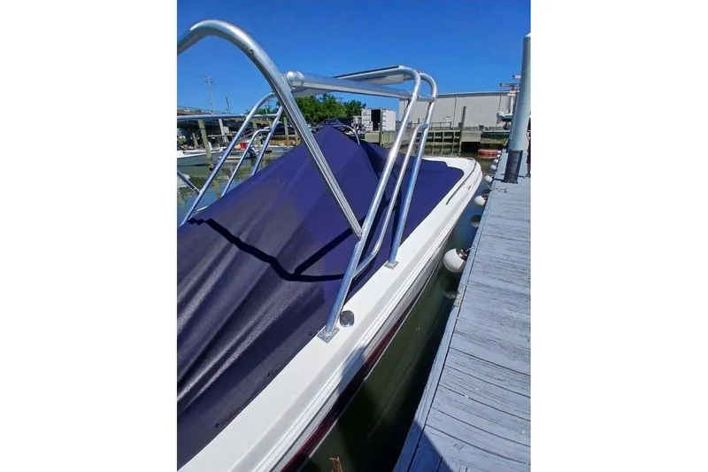 Slide: The Image of 1999 Wellcraft 302 Scarab Sport boat docked with blue cover and metal railings. - 20