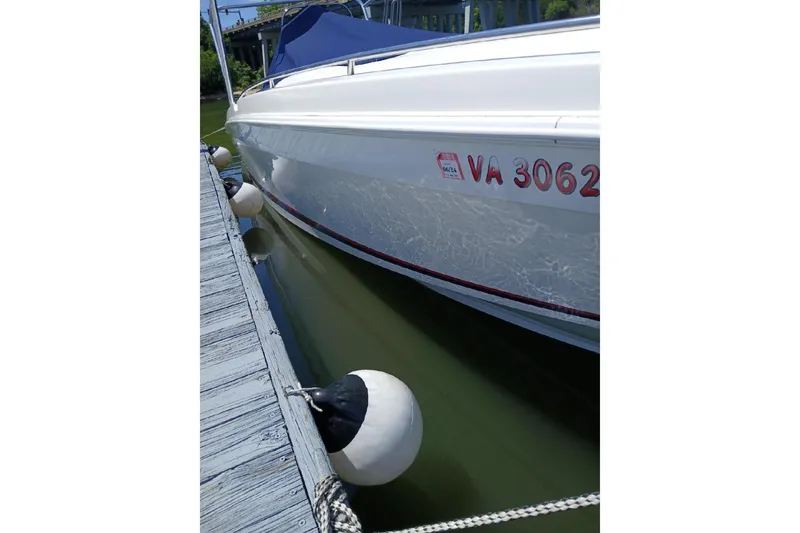 Slide: The Image of 1999 Wellcraft Scarab 302 Sport boat on gravel, side view with registration number visible. - 3