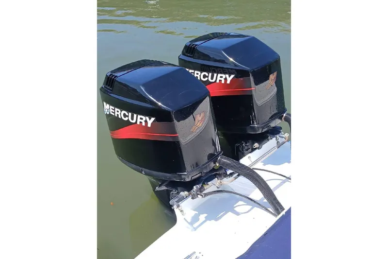 Slide: The Image of 1999 Wellcraft Scarab 302 Sport boat docked, covered, near a bridge on a sunny day. - 6