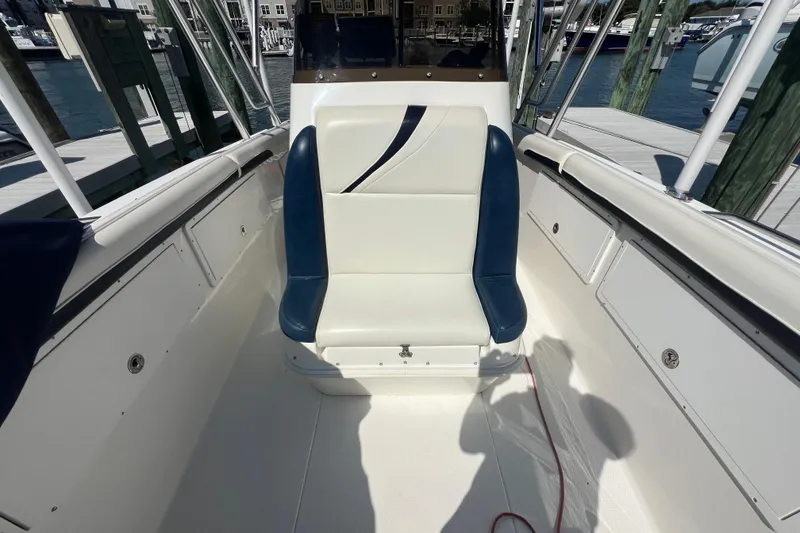 Slide: The Image of 1999 Wellcraft 302 Scarab Sport boat interior with white and blue seating at a marina. - 61