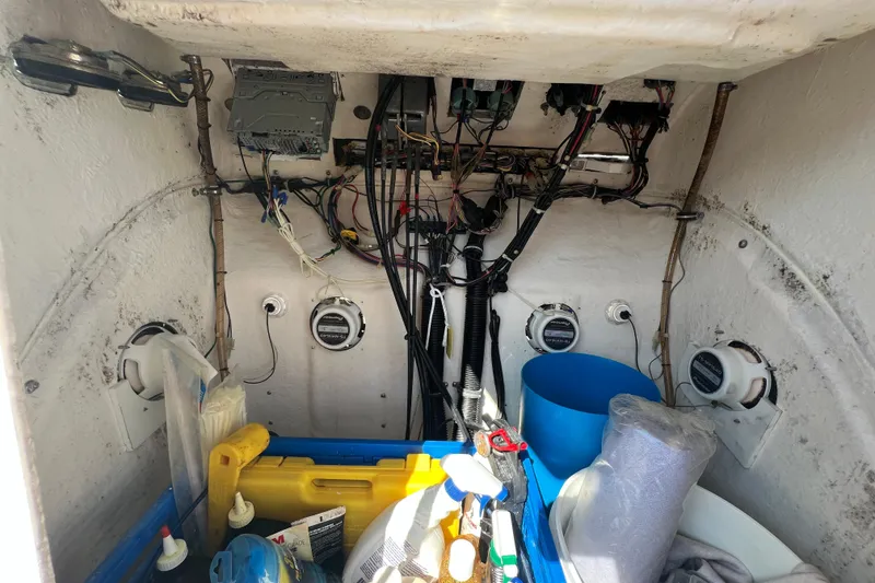 Slide: The Image of Interior view of a 1999 Wellcraft 302 Scarab Sport boat showing wiring and storage items. - 65