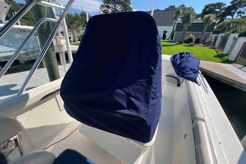 Slide: The Image of 1999 Wellcraft 302 Scarab Sport boat interior with covered console at dock. - 73