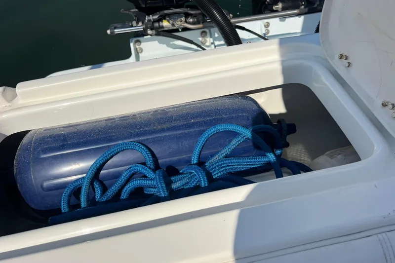 Slide: The Image of Storage compartment on a 1999 Wellcraft 302 Scarab Sport boat with blue rope and fender. - 75