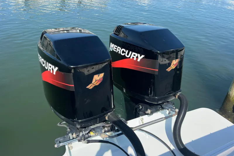 Slide: The Image of Twin Mercury outboard engines on a 1999 Wellcraft 302 Scarab Sport boat. - 78