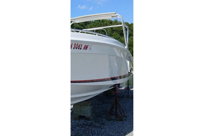 Slide: The Image of 1999 Wellcraft Scarab 302 Sport boat interior with seating, parked in a marina. - 8