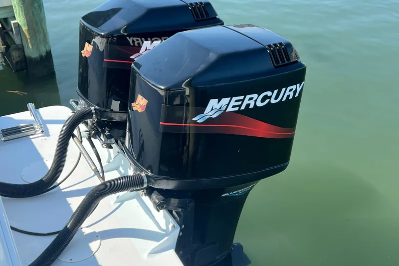 Slide: The Image of Twin Mercury outboard engines on a 1999 Wellcraft 302 Scarab Sport boat. - 83