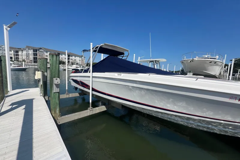 Slide: The Image of 1999 Wellcraft 302 Scarab Sport boat docked at marina under clear blue sky. - 86