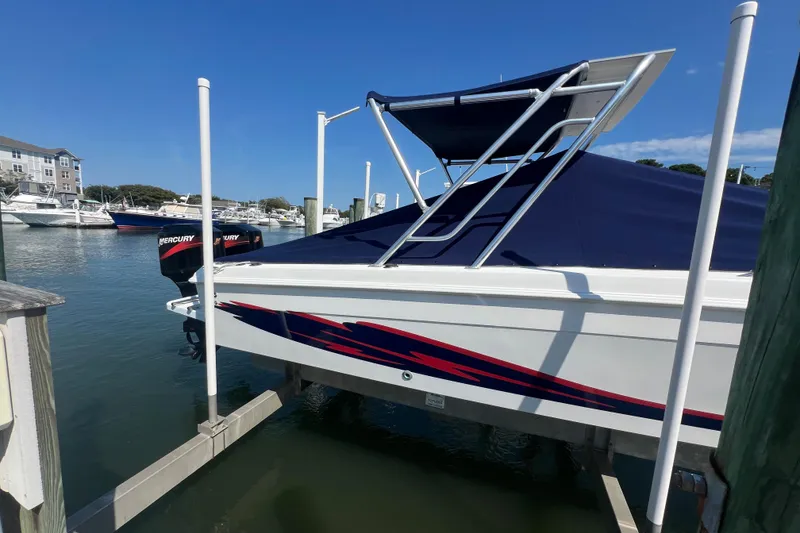 Slide: The Image of 1999 Wellcraft 302 Scarab Sport boat docked with blue cover and twin Mercury engines. - 87