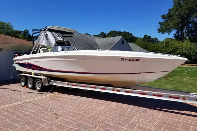 Slide: The Image of 1999 Wellcraft 302 Scarab Sport boat on trailer, parked in driveway. - 88