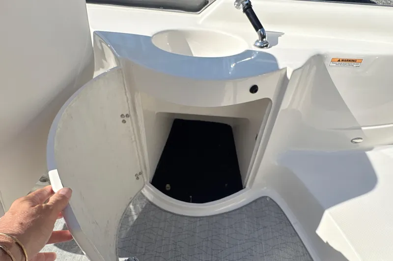Slide: The Image of 2022 Splendor 239 Sunstar boat interior with open storage compartment and sink. - 12