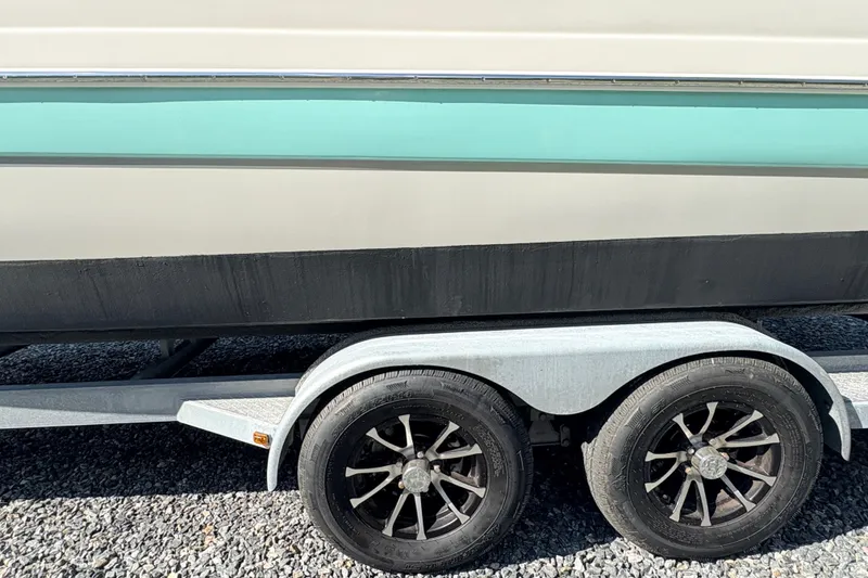 Slide: The Image of Trailer with Splendor 239 Sunstar boat, 2022 model, on gravel surface. - 7