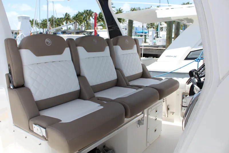 Slide: The Image of Luxurious seating on 2016 Edgewater 370CC boat, featuring elegant white and brown upholstery. - 16