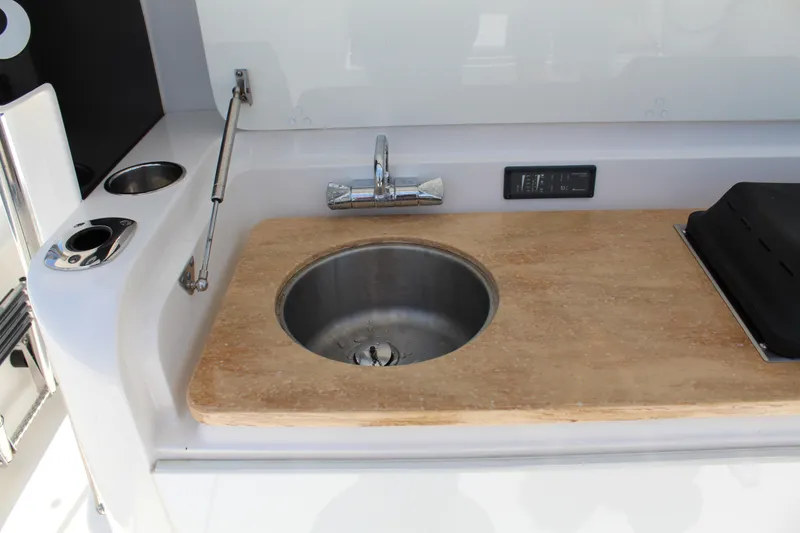 Slide: The Image of 2016 Edgewater 370CC boat sink and countertop with faucet and control panel. - 19