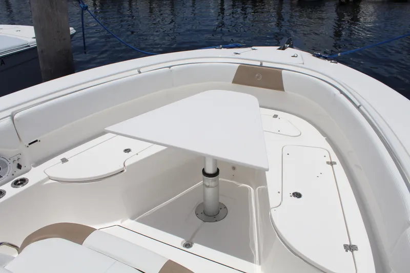 Slide: The Image of Edgewater 370CC 2016 boat interior with white seating and table on calm water. - 27
