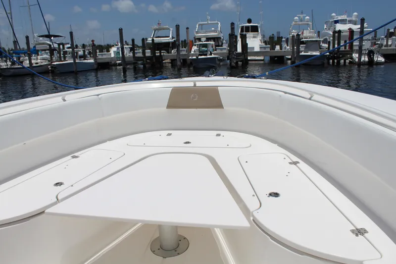 Slide: The Image of 2016 Edgewater 370CC boat interior at marina, showcasing spacious deck and seating area. - 28
