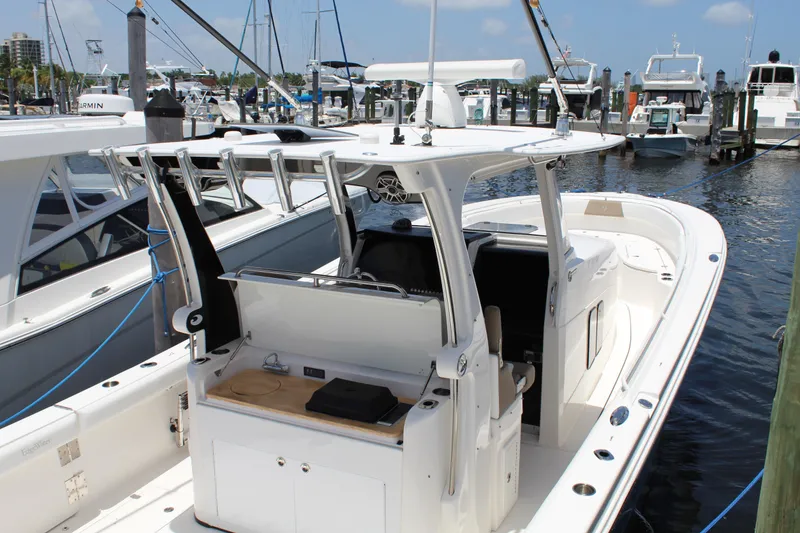 Slide: The Image of 2016 Edgewater 370CC boat docked at marina, featuring spacious deck and modern design. - 35