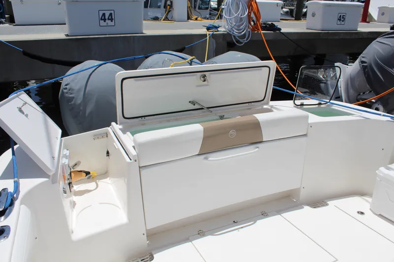 Slide: The Image of 2016 Edgewater 370CC boat interior with storage compartments and dock in background. - 38