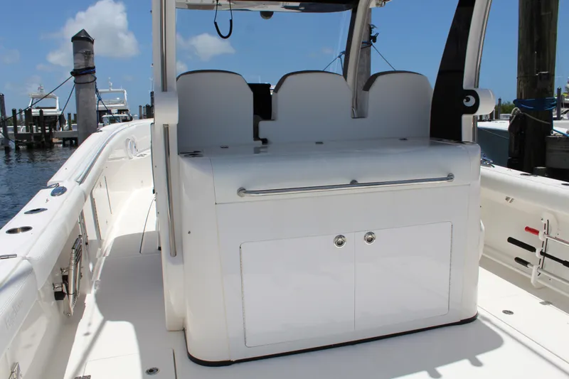 Slide: The Image of 2016 Edgewater 370CC boat interior with seating and storage, docked at marina. - 4