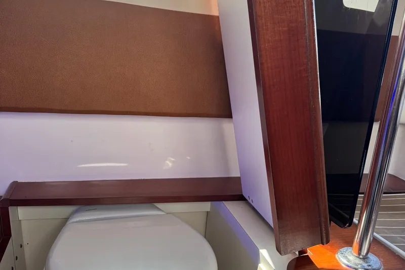 Slide: The Image of Interior of 2016 Edgewater 370CC boat featuring a compact bathroom area. - 42