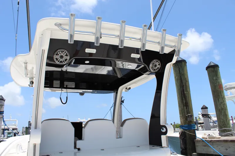 Slide: The Image of 2016 Edgewater 370CC boat with rod holders and speakers, docked under a clear blue sky. - 5