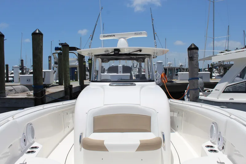 Slide: The Image of 2016 Edgewater 370CC boat docked at marina under clear blue sky. - 7