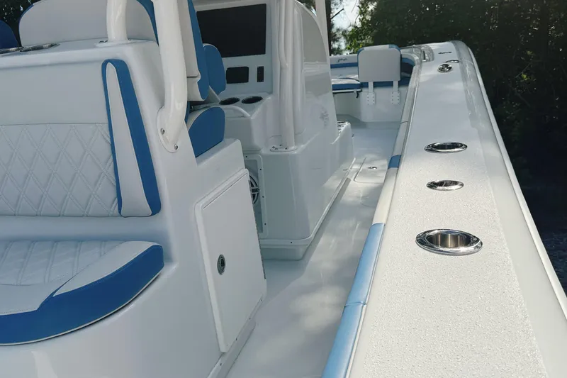 Slide: The Image of 2024 Yellowfin 36 Offshore boat interior with blue and white seating and rod holders. - 23