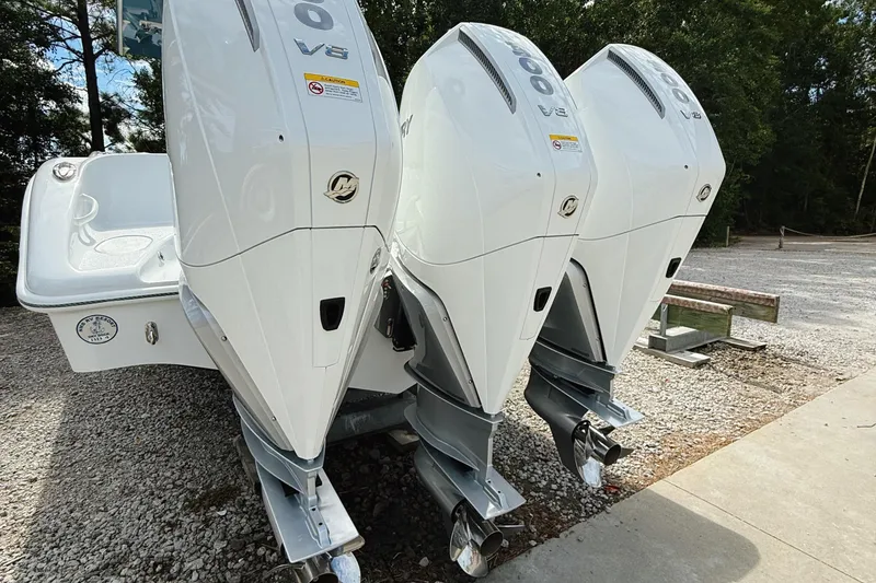 Slide: The Image of 2024 Yellowfin 36 Offshore boat with triple V8 outboard engines, parked on gravel. - 8