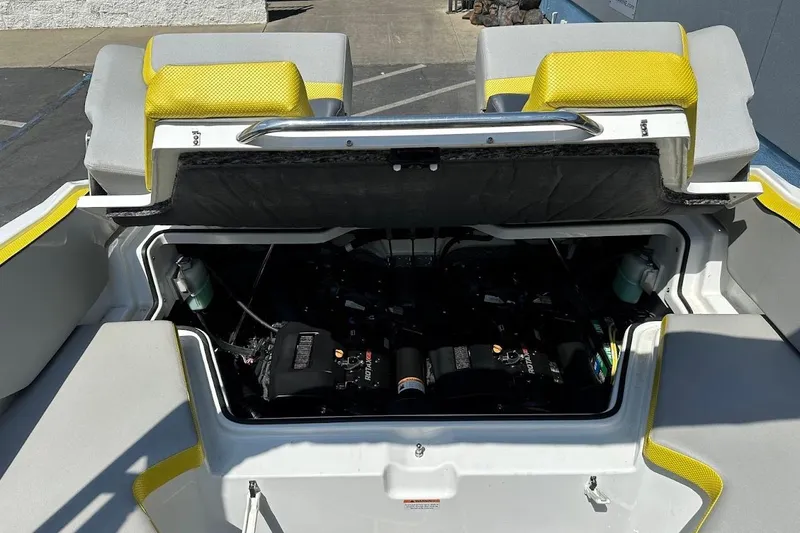 Slide: The Image of 2023 Scarab 215 ID boat engine compartment with yellow and gray seating. - 26