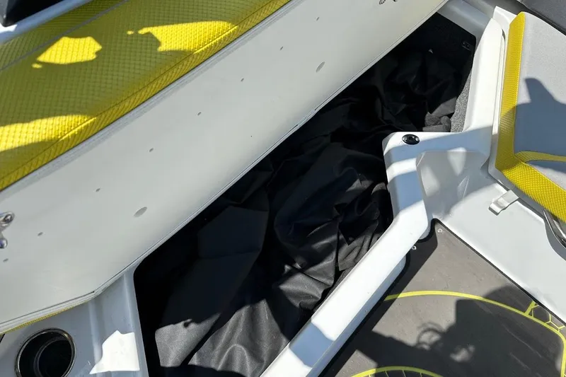 Slide: The Image of Interior storage compartment of 2023 Scarab 215 ID boat with yellow accents. - 30