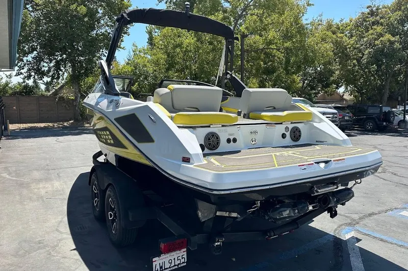 Slide: The Image of 2023 Scarab 215 ID boat on trailer, parked outdoors, showcasing sleek design and modern features. - 8