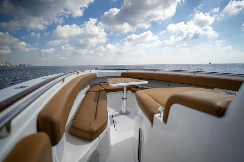 Slide: The Image of 2020 HCB 42 Lujo boat with tan seating, ocean view, and cloudy sky. - 13