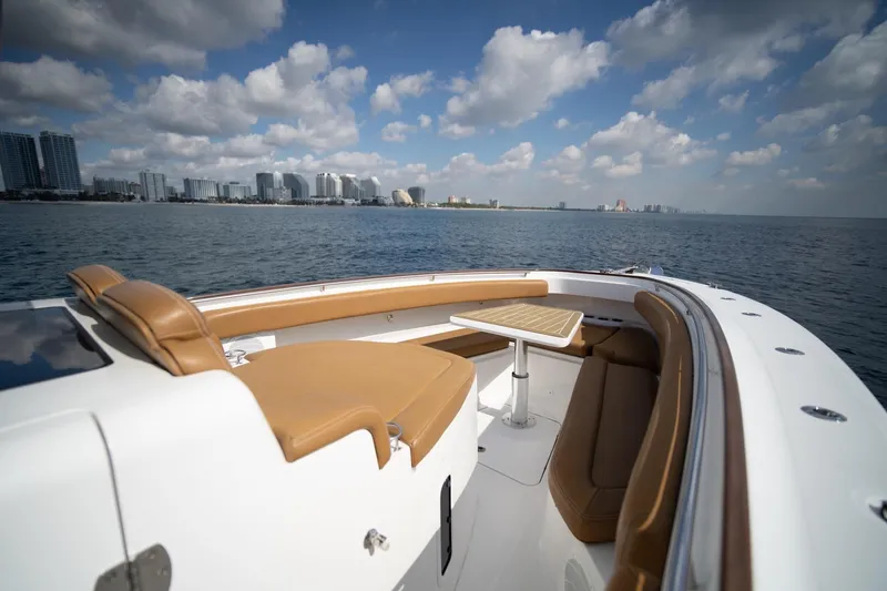 Slide: The Image of Luxurious 2020 HCB 42 Lujo boat with elegant seating, ocean view, and city skyline. - 14