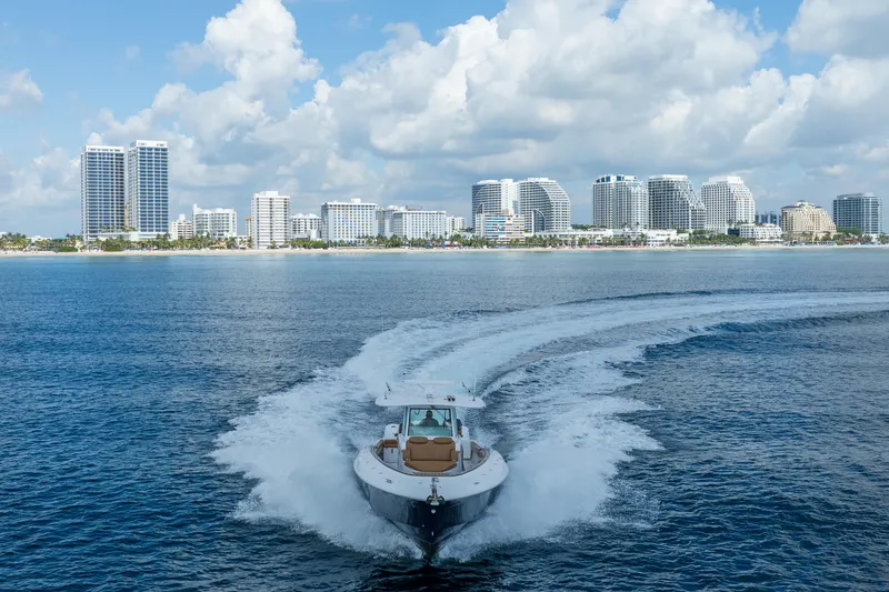 Slide: The Image of 2020 HCB 42 Lujo boat cruising near city skyline under cloudy sky. - 6