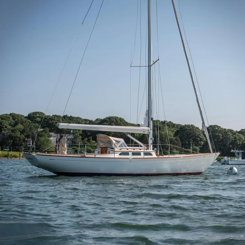 The Image of 2006 Morris M36 Daysailer on calm water, surrounded by lush greenery. - 0