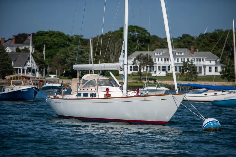Slide: The Image of 2006 Morris M36 Daysailer moored in scenic harbor with coastal homes in background. - 2
