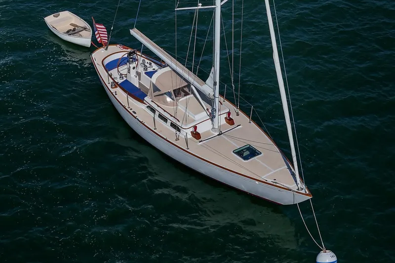 Slide: The Image of 2006 Morris M36 Daysailer anchored on calm waters with a small dinghy nearby. - 5