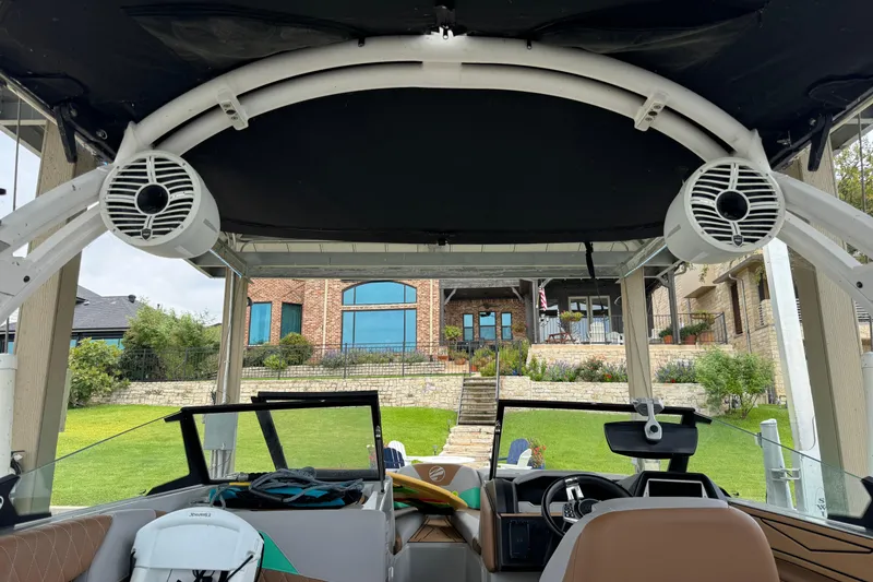 Slide: The Image of 2022 Tigé Z3 boat interior with speakers, docked near a brick house. - 10