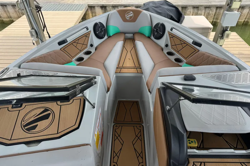 Slide: The Image of 2022 Tigé Z3 boat interior with brown and gray seating, cup holders, and stylish design. - 11