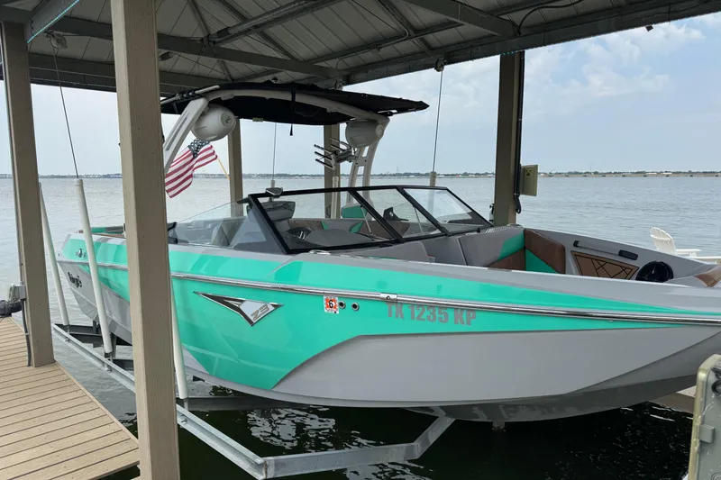 Slide: The Image of 2022 Tigé Z3 boat docked under a shelter with an American flag. - 4