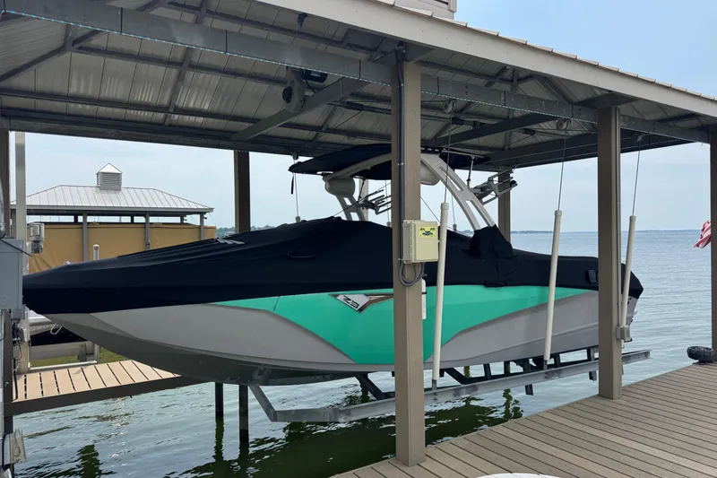 Slide: The Image of 2022 Tigé Z3 boat in dock, covered, with turquoise and white hull. - 5