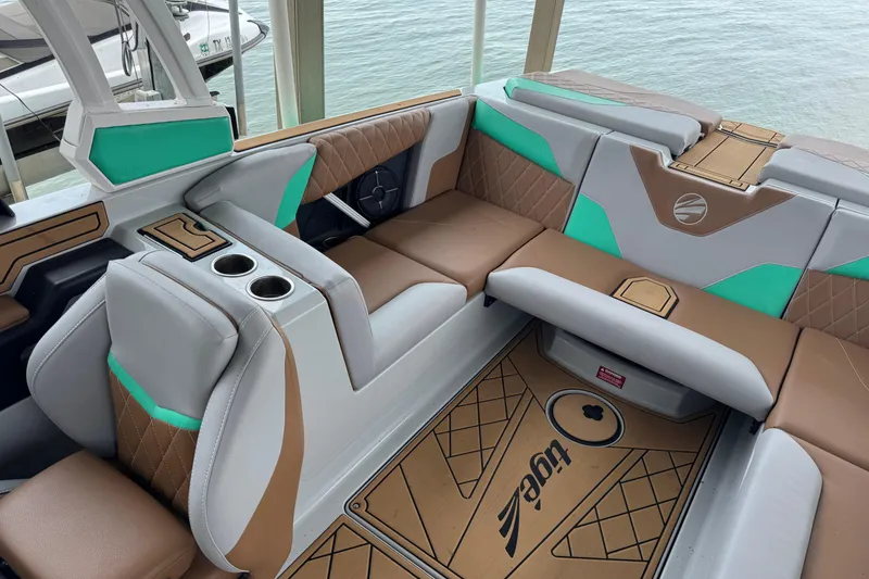 Slide: The Image of 2022 Tigé Z3 boat interior with stylish seating and cup holders, overlooking water. - 7