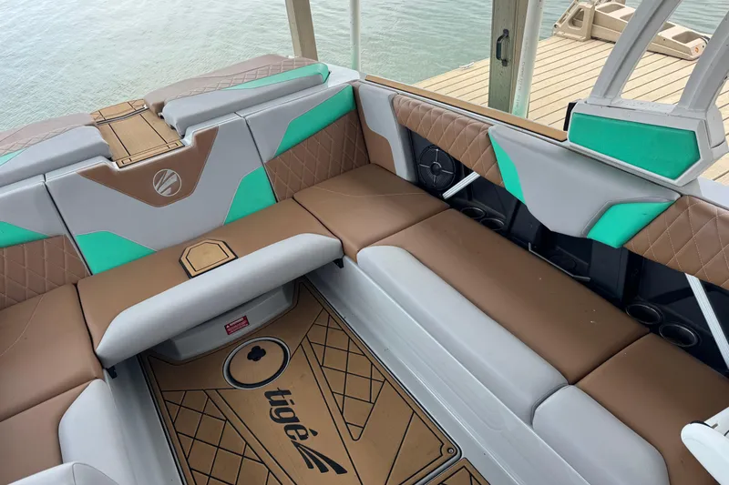 Slide: The Image of 2022 Tigé Z3 boat interior with brown and teal seating, dockside view. - 8