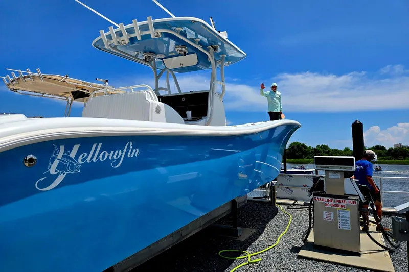 Slide: The Image of 2007 Yellowfin 36 boat at dock, vibrant blue hull, fueling station, clear sky. - 2