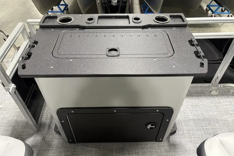 Slide: The Image of 2026 Sun Tracker SportFish 20 DLX battery compartment with visible wiring and storage space. - 25