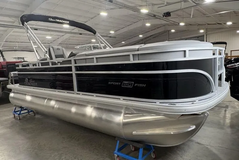 Slide: The Image of 2026 Sun Tracker SportFish 20 DLX pontoon boat on trailer in indoor showroom. - 7