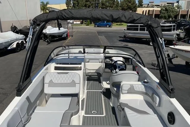 Slide: The Image of 2025 Bayliner VR6 Bowrider I/O boat interior with seating and steering wheel in a parking lot. - 16